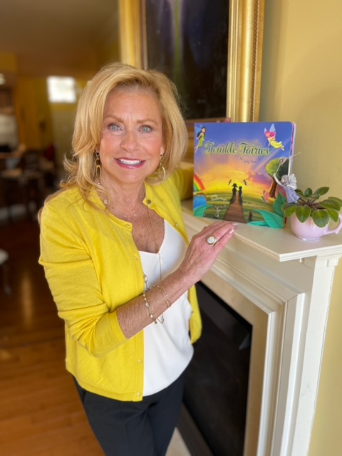 Author Judy Toma standing holding her book Twinkle Fairies