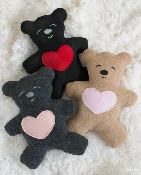photo of three small teddy bears with hearts on their tummies.